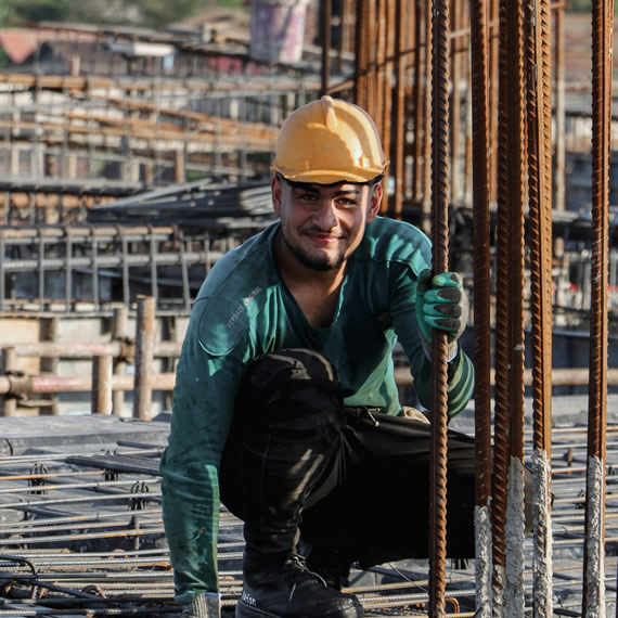 Contstruction worker crouched down looking at the camera